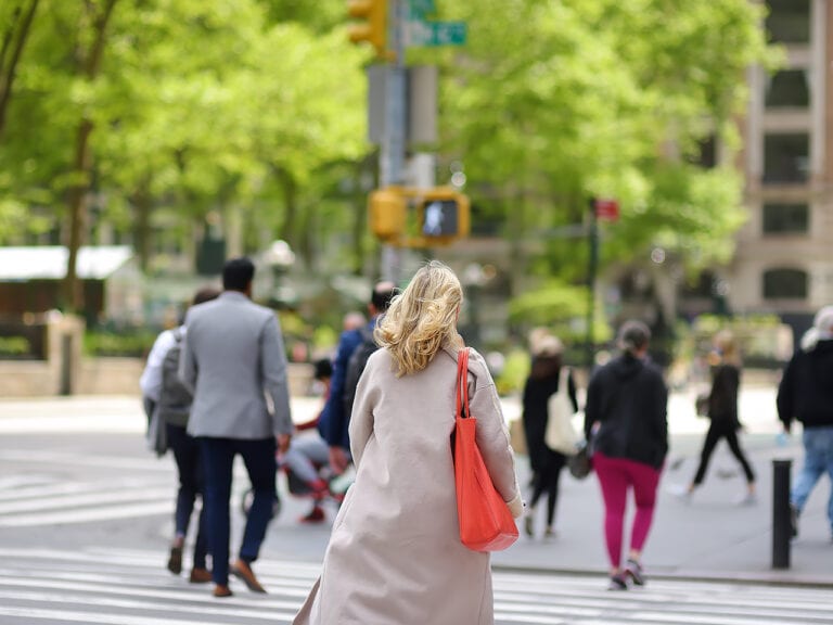 Group of people in the city crossing the street at a crosswalk intersection